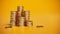 Gold Dollar coins stack, golden coin heap on yellow background.