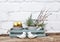 Gold Easter eggs in ceramic grey busket and spring grass with willow in decorayive grey watering can in purist blue box with white