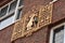 Gold emblem on a brick exterior wall, the Coendershuis