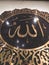 Gold embossed calligraphy bearing the name of God in Arabic "Allah"