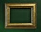 Gold empty picture frame border on green wall