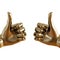 Gold figurine of a hand with a protruding thumb up on an isolated background. 3d rendering