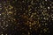 Gold foil confetti on black background. Flatlay