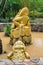 Gold frog sits on coins in pond with dirty water