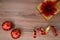 Gold gift box with red bouquet with red christmas bulbs and wrapping tape on a wooden table. Top view