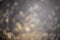 Gold glitter dust blurred lights background, defocused dark stylish texture