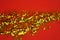 Gold glitter on red background. Celebratory Background. Golden Explosion Of Confetti