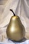 Gold / Golden Pear on crumpled white fabric background