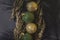 gold and green christmas baubles with gold painted cypress branches on a textured paper black background