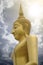 Gold image of Buddha with blue sky and cloud in background, light effect added , prachuapkhirikhan,thailand,filtered image