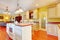 Gold kitchen with white antique cabinets.