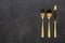 Gold knives, forks and spoons placed on a black background. Beautiful gold cutlery