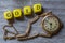 Gold letter cube and clock on gray wood visualization