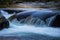 Gold light water reflections over water falling over rocks