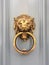 Gold lion head door knocker with the ring on its mouth on the entrance of a house, Malta. Italian traditional doorknob.