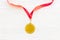 Gold medal with red ribbon - winner, success concept - on white wooden background top view