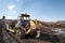 Gold mining industry. Bulldozer rake gold-bearing mountain soil into a heap