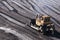 Gold mining industry. Bulldozer rake gold-bearing mountain soil into a heap