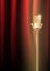 Gold old microphone against the illuminated red curtain background