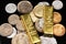 Gold one ounce ingots with coins from Pakistan on a black reflective background