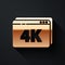 Gold Online play video with 4k Ultra HD video technology icon isolated on black background. Film strip with play sign