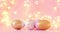 Gold and pink eggs pattern on a light blurry garland. Shallow depth of field.