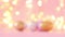 Gold and pink eggs pattern on a light blurry garland. Shallow depth of field. Holiday concert