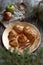 A gold plate of apple dumplings with cinnamon sticks and rustic props
