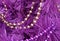 Gold and purple bead garlands strung on an artificial Magenta colored tree