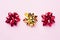 Gold and red Christmas bows on pink background. Gift concept greetings for holidays birthday Wedding New year Christmas mother`s