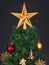 Gold, red and straw vintage decorations in the Scandinavian style on an artificial Christmas tree isolated on a black