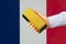 gold reserve of the France concept. Gold bar in hand on French flag background