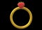A gold ring with a strawberry topping against a black backdrop