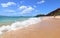 Gold sand beach walker. Blue sea water and dramatic clouds. Maui, Hawaii, USA. Unidentifiable sun bather.