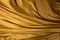 Gold Satin background textured. Soft folded cloth as background texture. Golden Clothing texture.