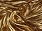 Gold satin fabric with waves. Golden background