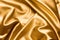 Gold silk background  satin fabric background. Pleated fabric.