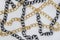 Gold, silver and black colors chains on white leather background