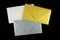 Gold, silver and white envelopes on black