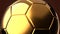 Gold soccer ball on brown background.