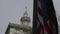 A gold statue of lady justice in the background is led by a billowing American flag