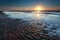 Gold sunset over North sea sand beach at low tide