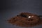 Gold teaspoon in a pile of ground or instant coffee on dark background