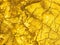 Gold texture rough leaf foil with crack background. Bright shiny yellow textured golden stone