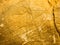 Gold texture rough leaf foil with cracks background. Shiny yellow textured golden stone wall