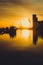 Gold toned sunrise over Dublin Bay and the docklands with cityscape including the Poolbeg Chimneys