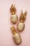 Gold tropical pineapple on a pastel pink background. Flat lay summer background