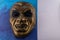 Gold Vampire Mask close up on blue background. Concept of Halloween fun for kids