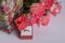 Gold wedding ring in a red box and a bouquet of pink roses. Romance. Marriage proposal