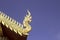 Gold wooden dragon head on Thai traditional eaves roof at temple in Thailand